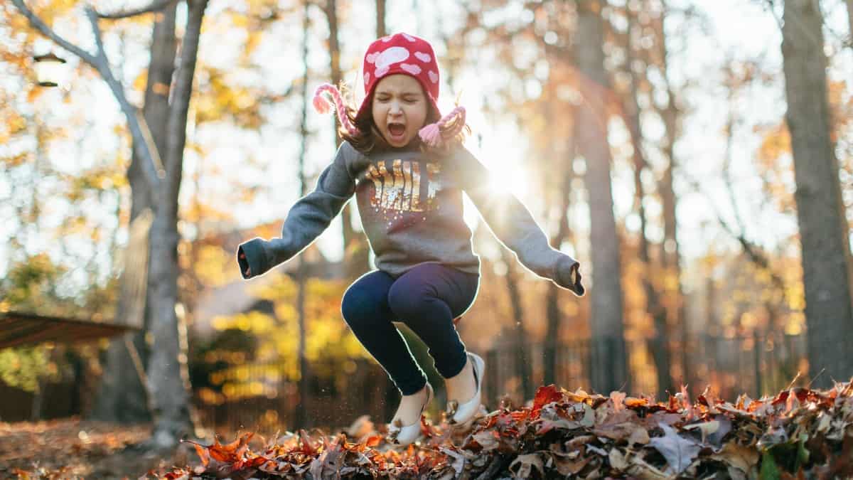 little girl doing outdoor fall activities