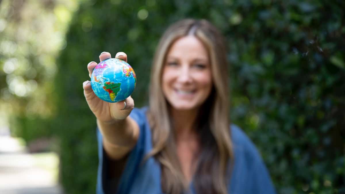 Patricia Bannan holding small earth in hand to celebrate earth month