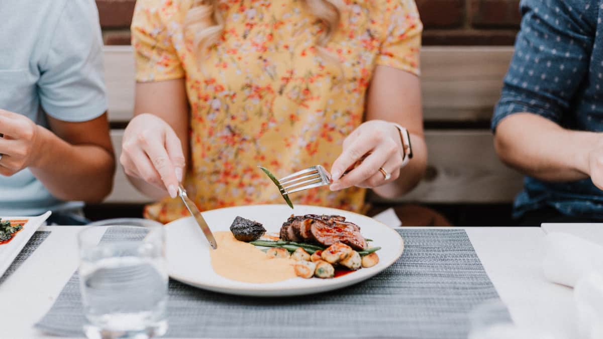 woman eating mindfully at table with small bite of food