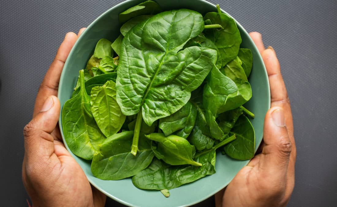 potassium in spinach man holding bowl of spinach