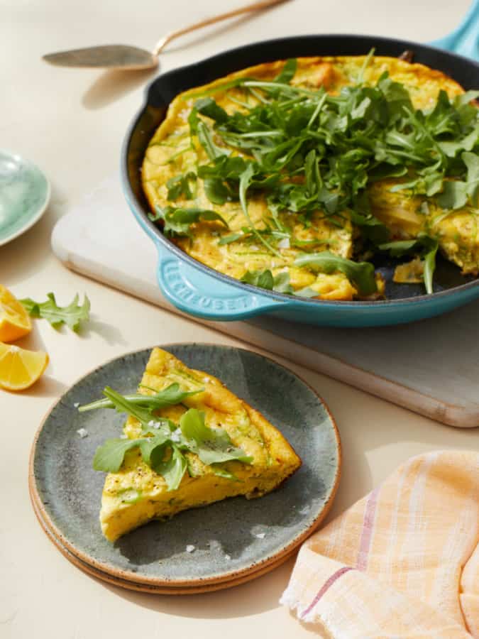 potato frittata with shaved asparagus and arugula in iron pan