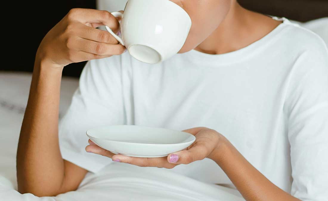 woman drinking tea in bed