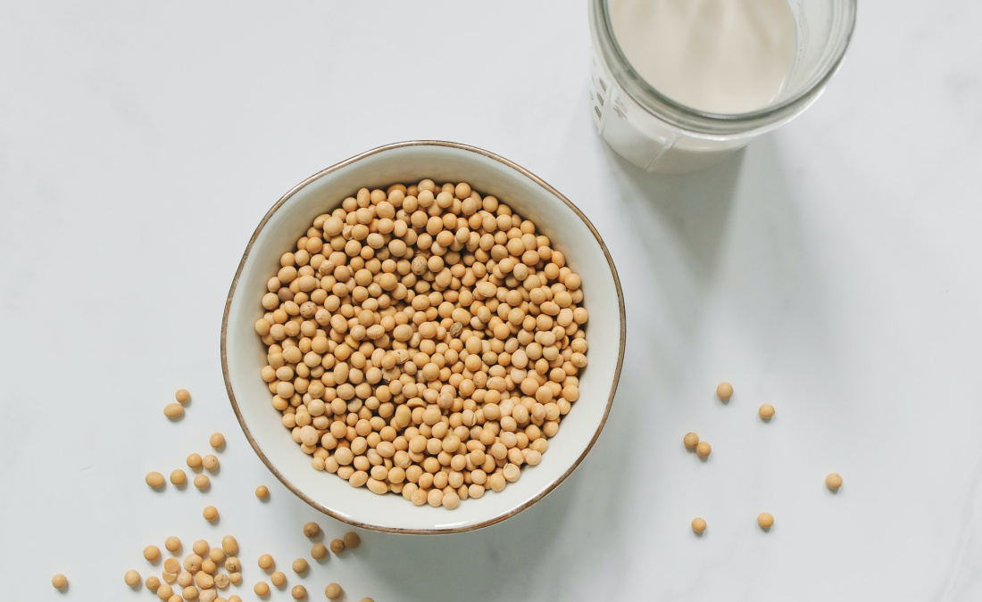 soybeans in a bowl with a glass of soymilk